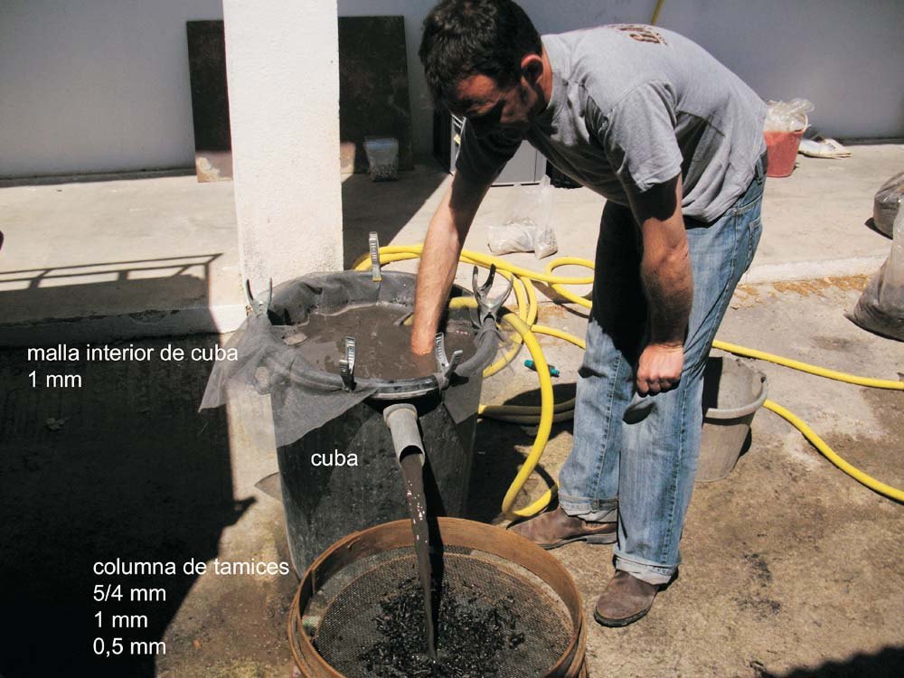 Un arqueòleg renta sediment en una màquina de flotació