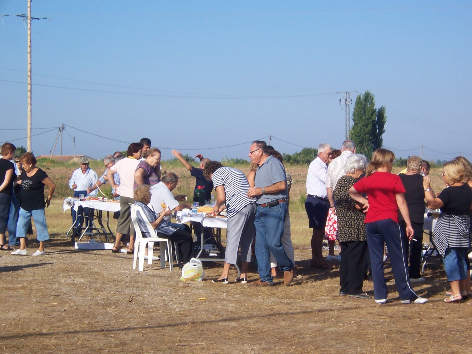 Veïns dinant a l'aire lliure en una festa